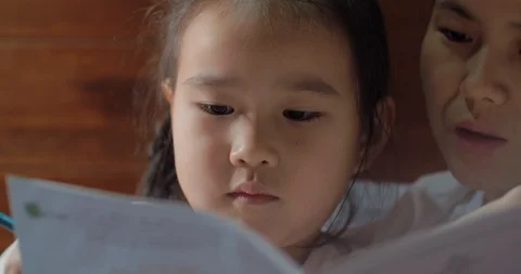 asian mother reading story to her little... | Stock Video | Pond5