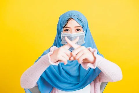 Asian Muslim Arab woman Islam wear hijab and face mask show fingers crossed t Stock Photos