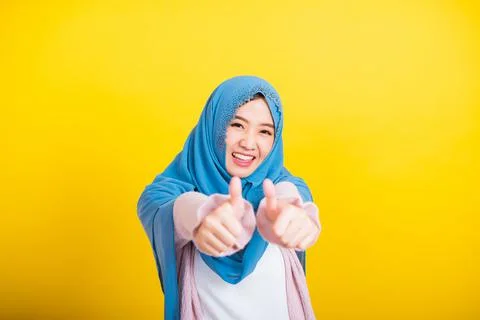 Asian Muslim Arab woman Islam wear hijab she made finger thumbs up, Ok sign t Stock Photos