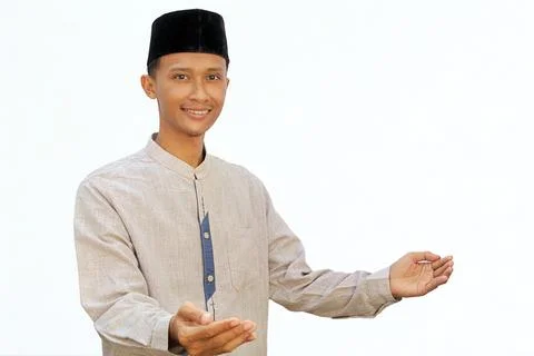 An Asian Muslim man opens both hands with a happy expression, showing a wel.. Stock Photos