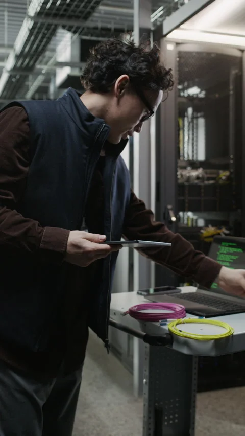 Asian Network Engineer Using Walkie Talkie with Tablet in Data Center Stock Footage 330546420