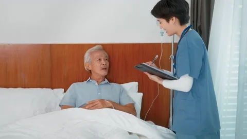 Asian nurse taking care of an elderly man lying on patient bed at  senior h.. Video stock 226319799