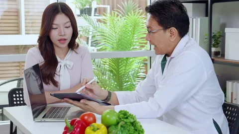 Asian nutritionist using tablet to explaining personalized meal plan with A.. 動画素材 329456249
