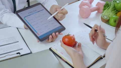 Asian nutritionist using tablet to explaining personalized meal plan with A.. 動画素材 329456319