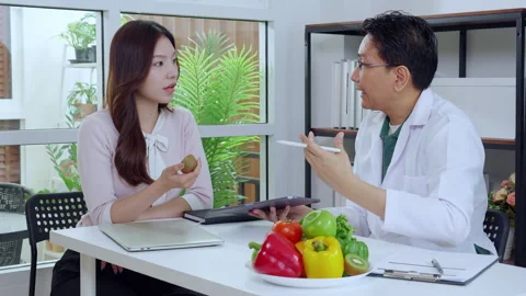 Asian nutritionist using tablet to explaining personalized meal plan with A.. 動画素材 332321559