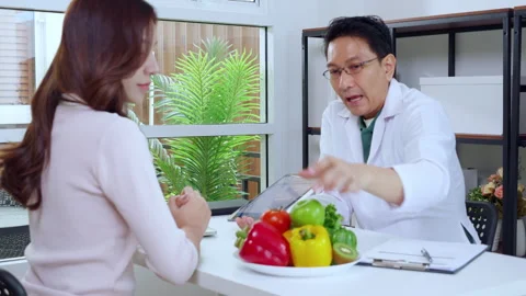 Asian nutritionist using tablet to explaining personalized meal plan with A.. 動画素材 332659692