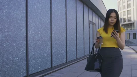 Asian office worker using phone, drinking coffee Stock Footage 89636104