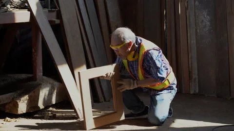 Asian old carpenter man using sandpaper on a piece of wood for furniture in w Stock Footage 157999794