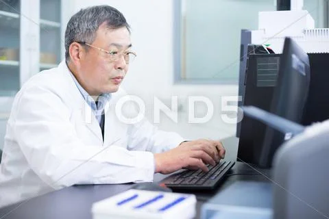 Asian Old Man Analysises Experimental Data In Lab