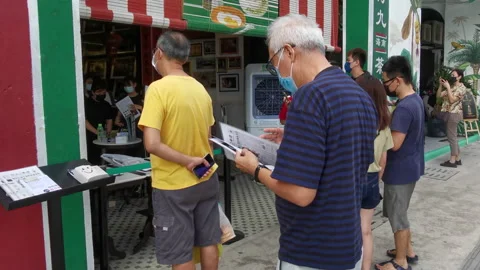 An Asian Old Man Standing While Browsing Menu Outside Of A Restaurant Stock-Footage 154070168