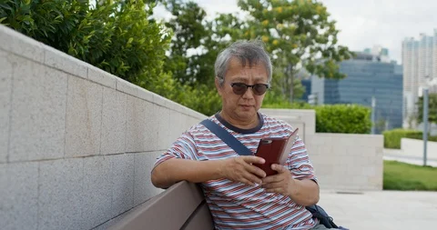 Asian old man use of smart phone at outdoor Stock Footage 115890454