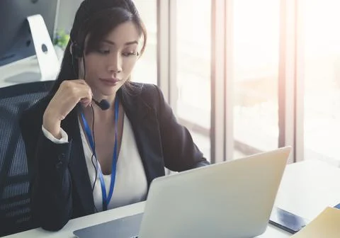 Asian Operator, Customer service assitance is answering call from client over Stock Photos