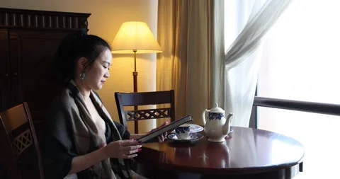 Asian origin middle aged attractive woman sitting at retro vintage room table Stock Footage 172051015