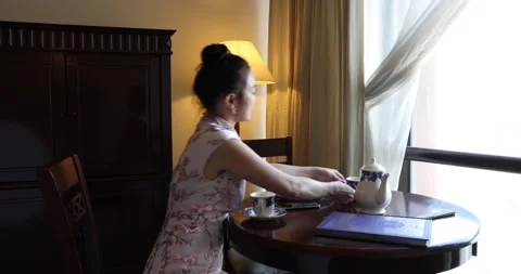 Asian origin middle aged attractive woman in cheongsam sitting at retro vinta Stock Footage 172051089