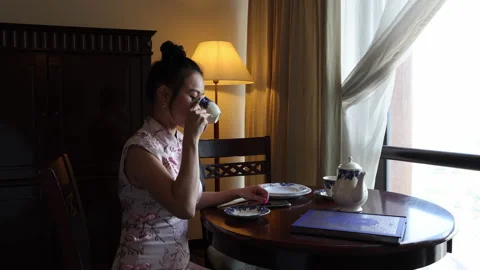 Asian origin middle aged attractive woman in cheongsam sitting at retro vintage  Stock Footage 172051243