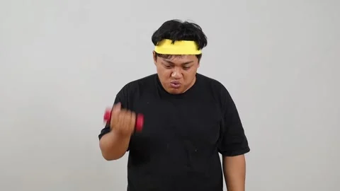Asian overweight guy lifting weight, determined to lose weight doing exercise Stock Footage 342230141