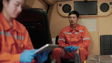 Asian paramedic worker is sitting in a car to pick up a patient Stock Footage 196940468