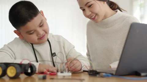 Asian parent teach kid learn coding toy stem car at home. Video stock 152604306
