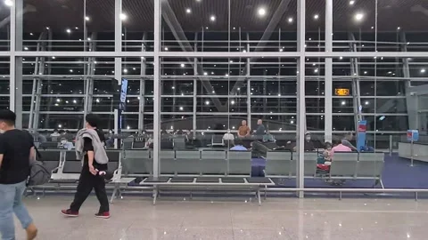 Asian passengers siting inside waiting area of the airport terminal Stock Footage 239780138