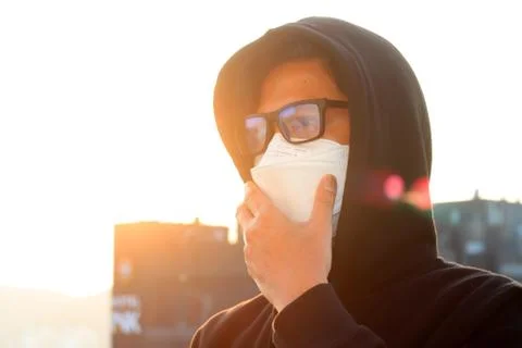 Asian people wear masks to protect the corona virus, against sunset, warm ton Stock Photos