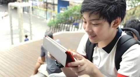Asian preteens watching on tablet computer , smile face. Stock Photos