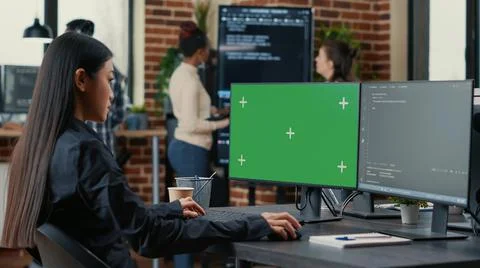 Asian programer writing code in front of computer with green screen chroma key Stock Photos