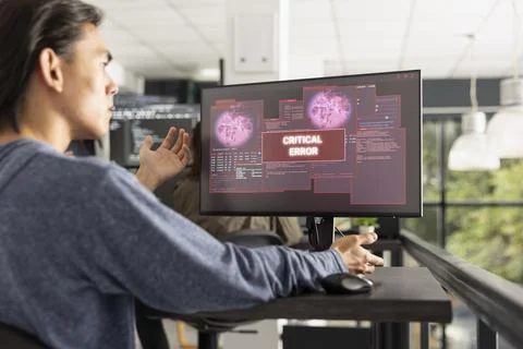 Asian programmer frustrated by critical system error alert Stockfoto's