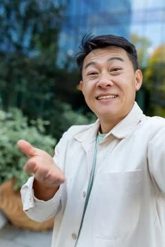Asian programmer talking on video call using app on phone, view camera man Stock Photos