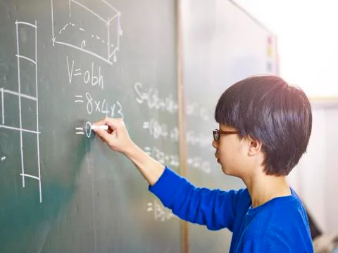Asian pupil solving a math problem Foto stock