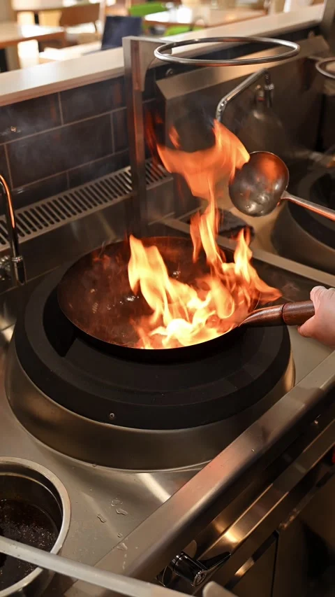 Asian restaurant kitchen. Chef stir-frying ingredients in a seasoned wok pa.. 스톡 동영상 338053070