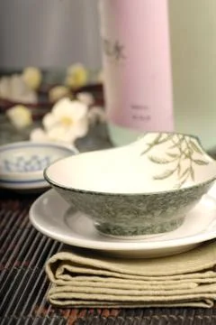 Asian restaurant table setup with sake and flowers Stock Photos