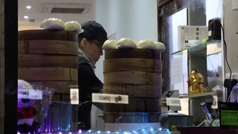 Asian restaurant worker preparing steamed dumplings, Baozi street food. Stock Footage 334319891