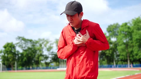 Asian runner man having heart attack or chest pain after running workout. Video stock 248123671