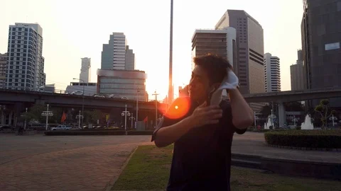 Asian runner stop run and use towel during sunset Video stock 102943487
