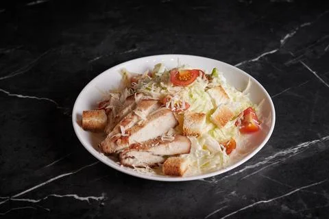 Asian salad with meat and seafood, shrimp, plate close-up on a dark background Stock Photos
