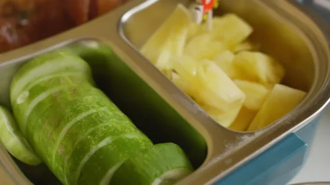 Asian school lunchbox on a table, melon, pineapple, cucumber, bao, sausage Stock Footage 288852867