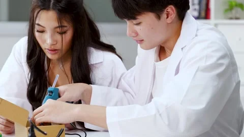 Asian Science Students Using Hot Glue Gun for Engineering Project Stock Footage 341917228