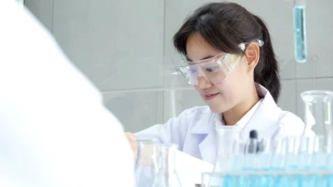 Asian Scientist drop solid in test tube. Science work at laboratory. Stock Footage 92990083
