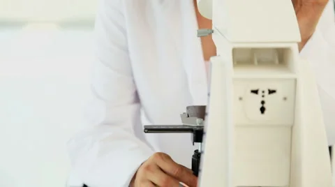 Asian Scientist Looking into Microscope Stock Footage 940801