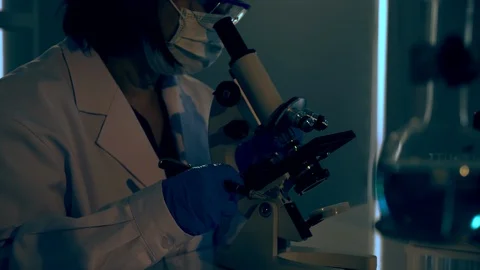Asian scientist or doctors use microscopes to test for corona virus (COVID19) Stock-Footage 125524906