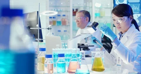 Asian scientist use microscope Stock Footage