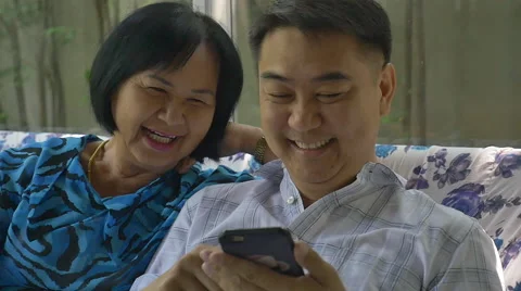 Asian senier woman and asian man using smart phone together Stock Footage