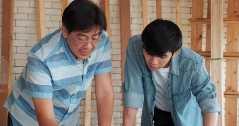 Asian senior carpenter teaching apprentice while working together in workshop Video stock 162826616
