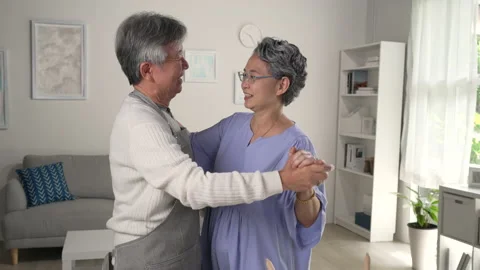 Asian senior couple is dancing while cooking together in kitchen at home. Stock Footage 221303283