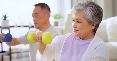 Asian senior couple doing exercise together in living room. Stock Footage 255270179