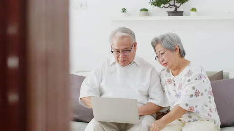 Asian senior couple using computer laptop at home Stock Footage 142770976