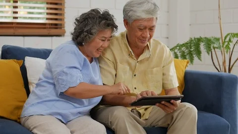 Asian senior couple using tablet searching online shopping. Sharing social me Stock Footage 101379478