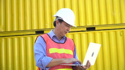 Asian senior Foreman wareing holding laptop computer talking on the walkie-.. Video stock 241719787
