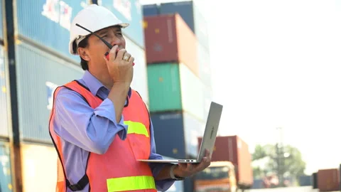 Asian senior Foreman wareing holding laptop computer talking on the walkie-.. Video stock 241721453