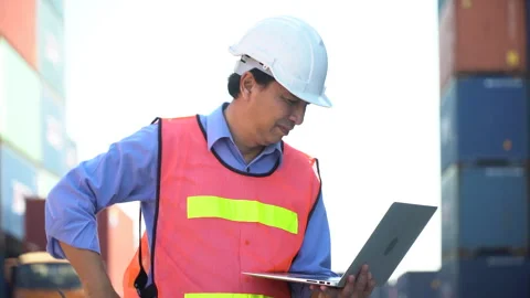 Asian senior Foreman wareing holding laptop computer talking on the walkie-.. Stock Footage 241725161